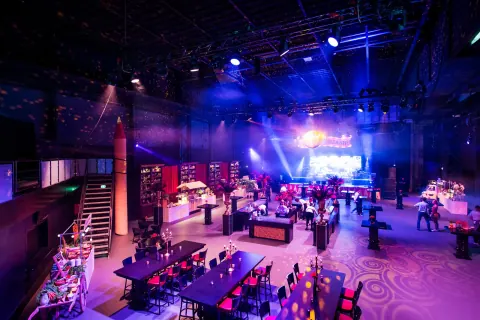 Hall set up with tables and a stage